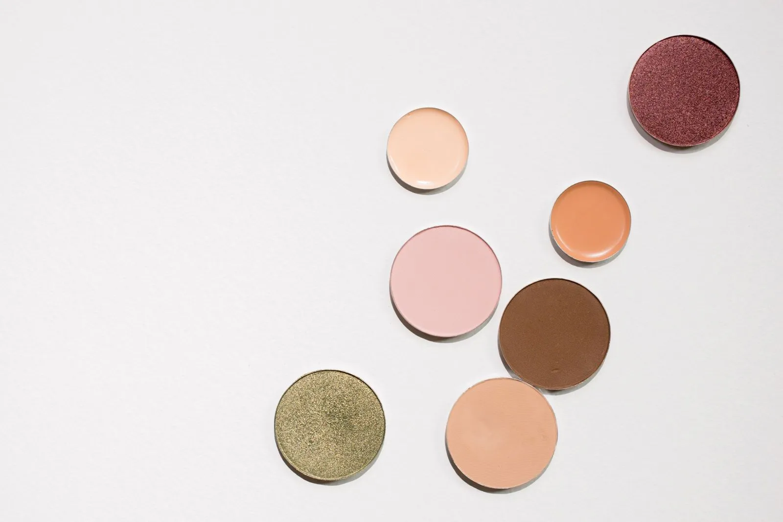 A collection of colorful eyeshadows displayed on a white surface