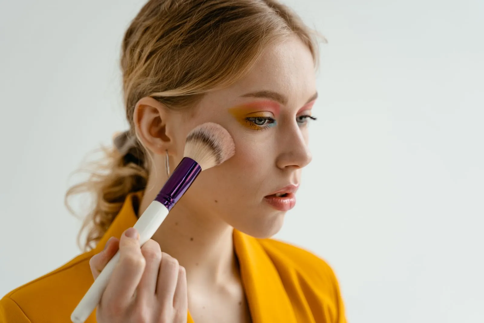 Woman using a makeup brush to apply blush