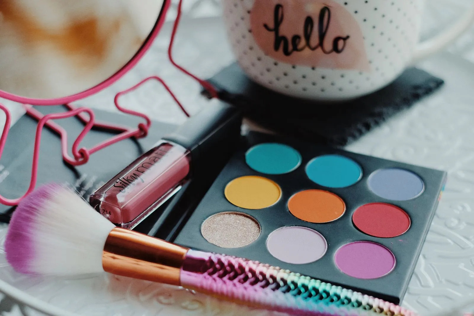 Vibrant eyeshadow palette with lipstick and brush