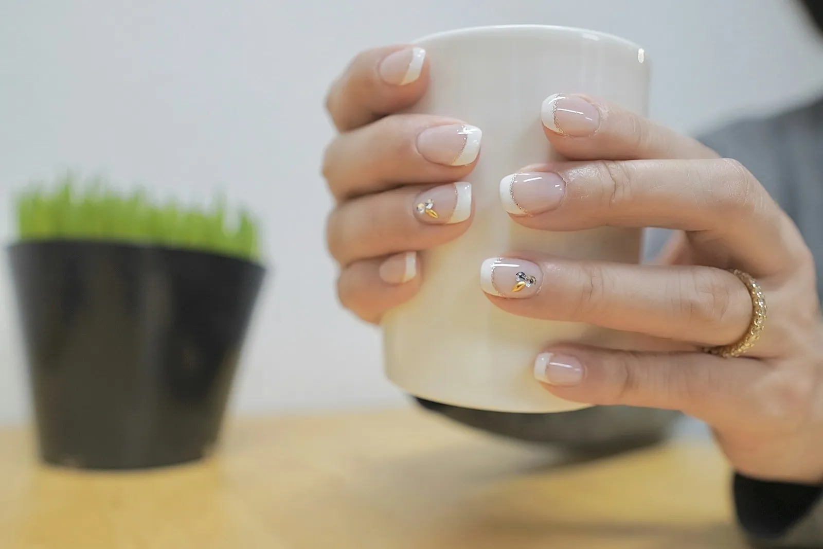 A lady with polished nails holding a cup