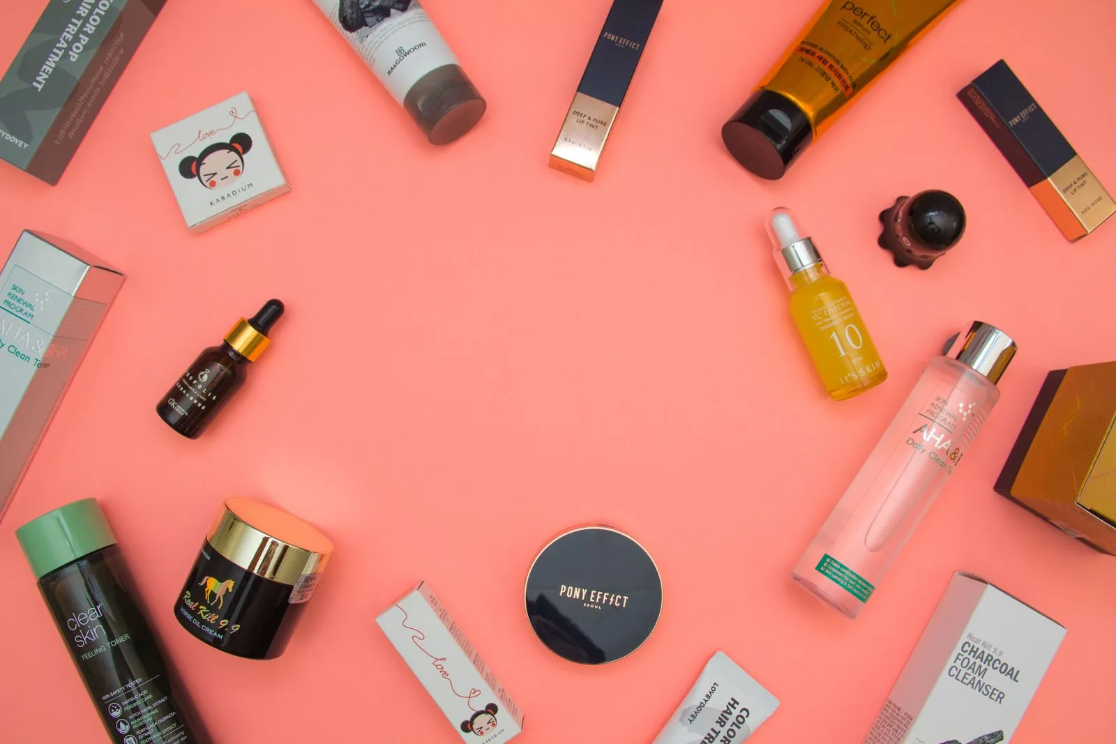 Top view of various cosmetic products for skincare and beauty in different bottles placed on pink surface