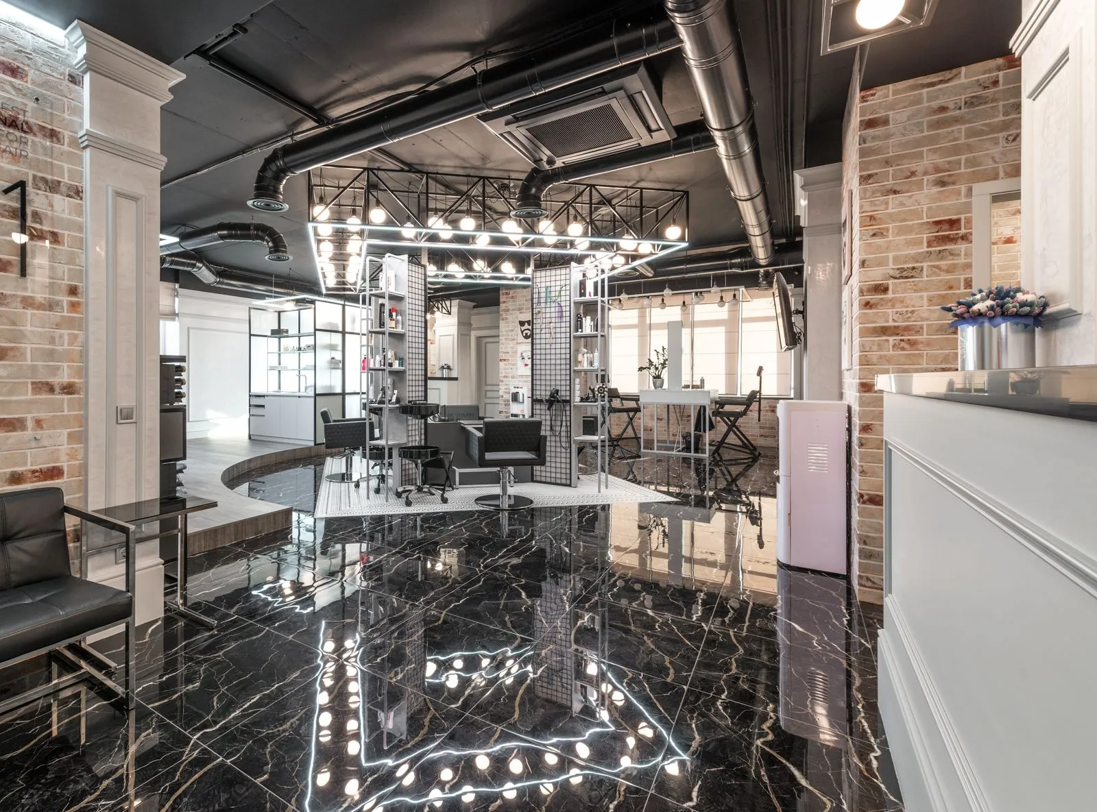 Reception desk with flowers placed in spacious light beauty salon with cosmetology equipment and shelves with supplies u