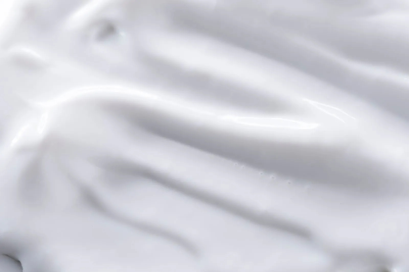 A detailed close-up of a smooth white cream texture