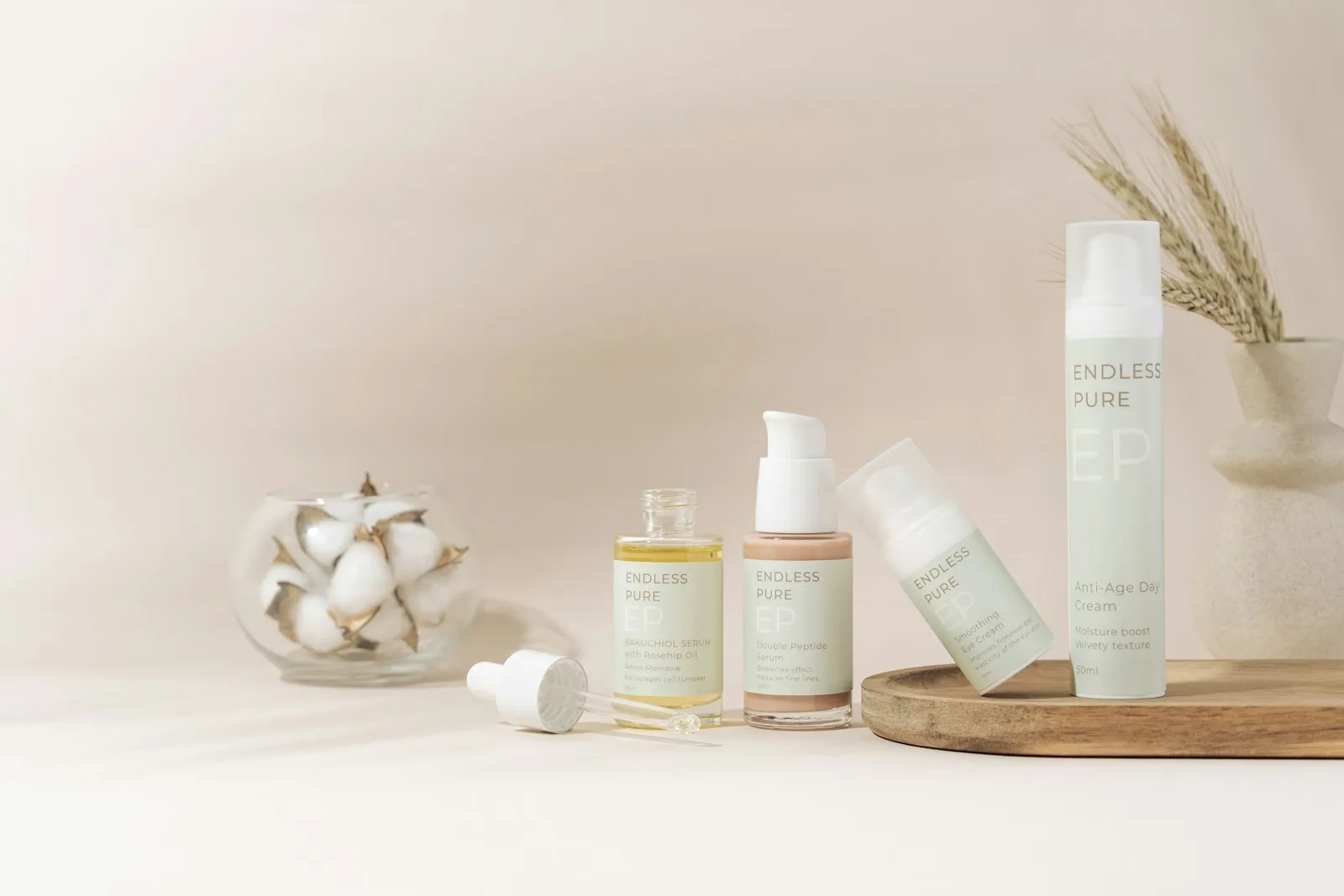 A beautifully arranged display of elegant skincare products on a marble tray against a soft, beige backdrop. The collect