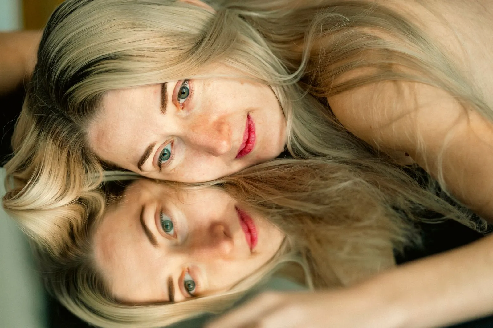 Close-up portrait of a woman with mirror reflection, creating a serene and contemplative mood.