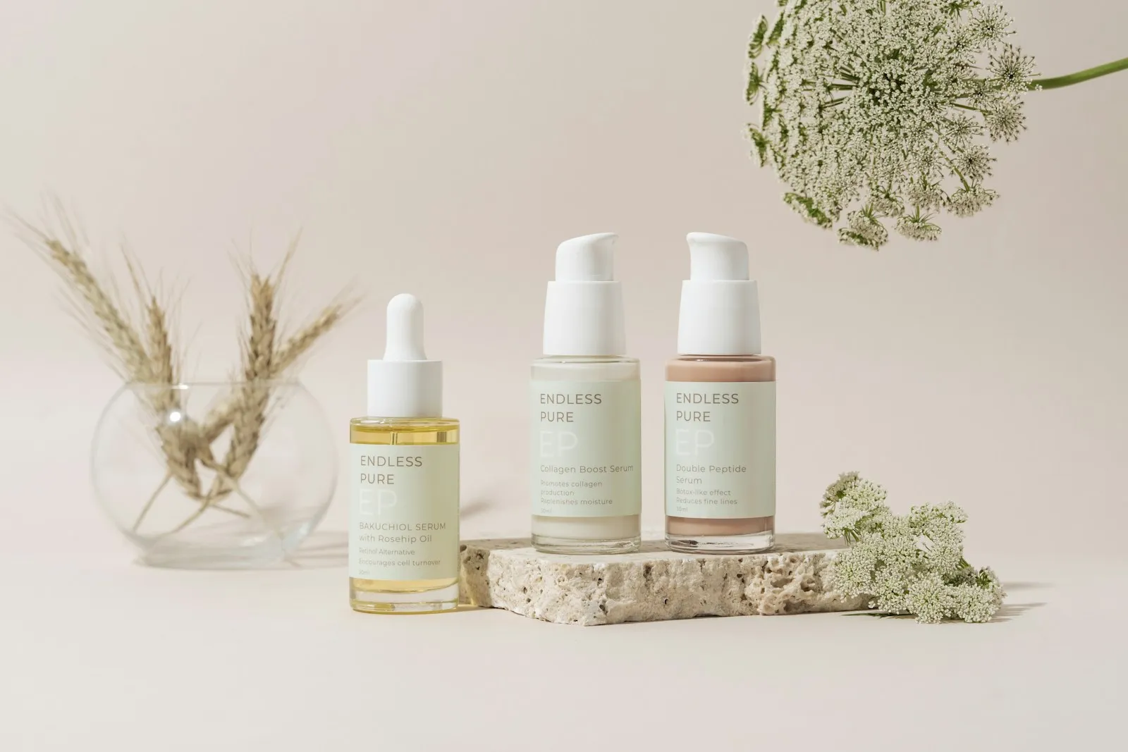An elegantly organized collection of skincare products showcased on a marble tray, set against a soft beige backdrop. Th