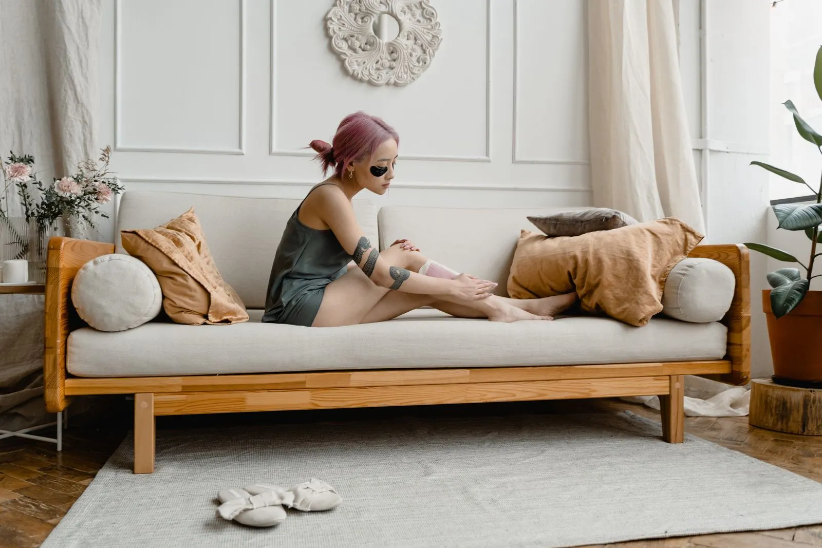 An adult woman waxing her legs at home