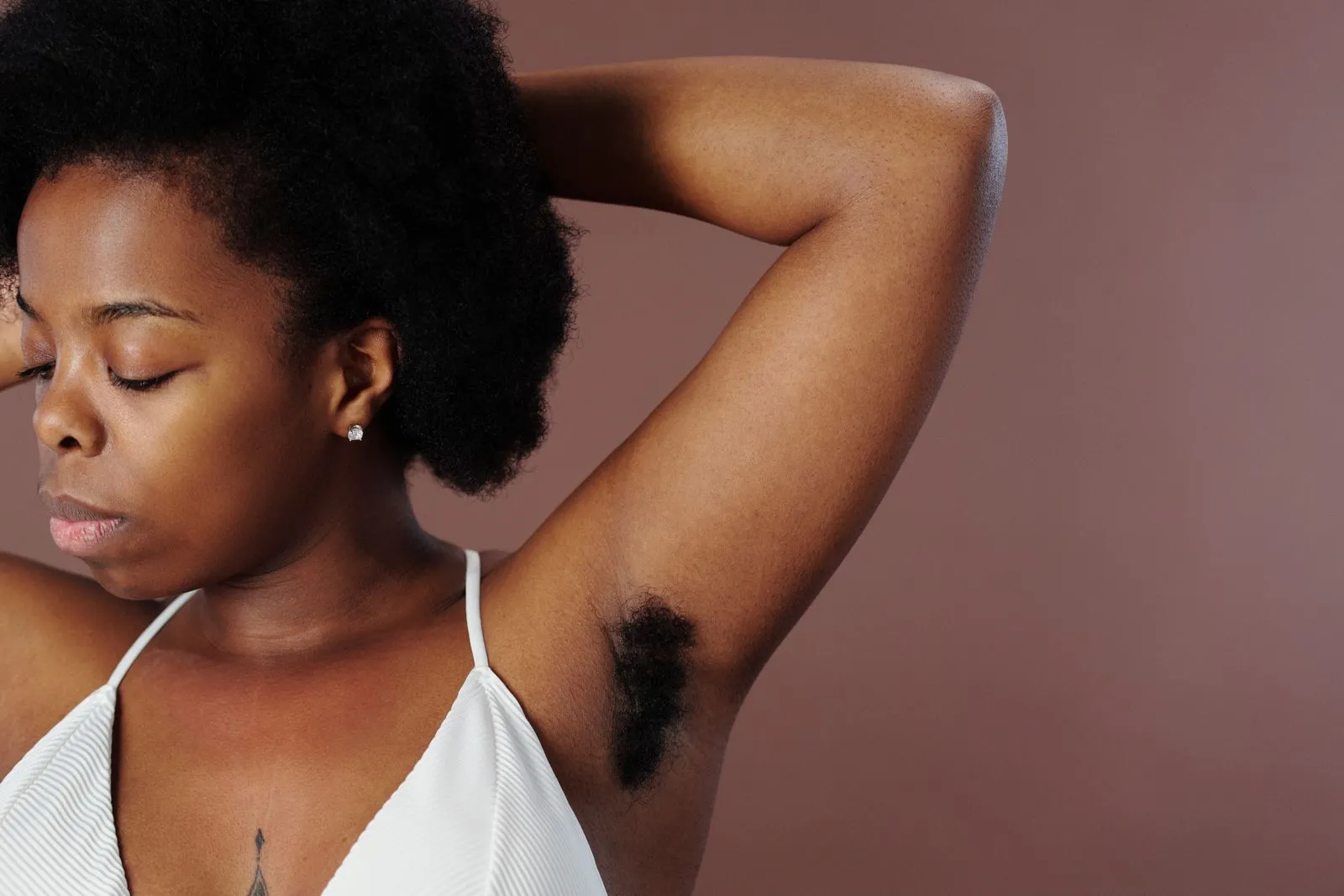 Close-up of a woman with natural afro hair showing self-expression in a studio.
