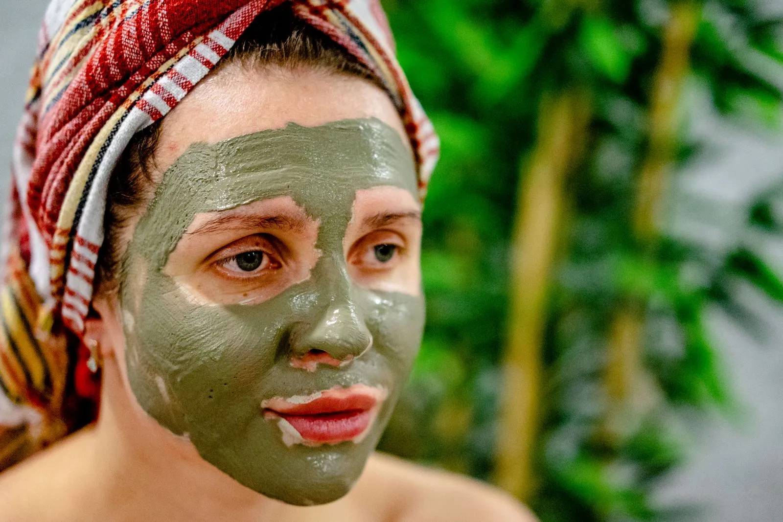 Woman enjoying a rejuvenating mud mask treatment at a spa, promoting relaxation and skincare.