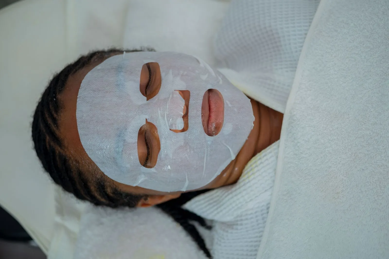 Woman enjoying a rejuvenating facial mask treatment at a spa in Abuja, Nigeria.