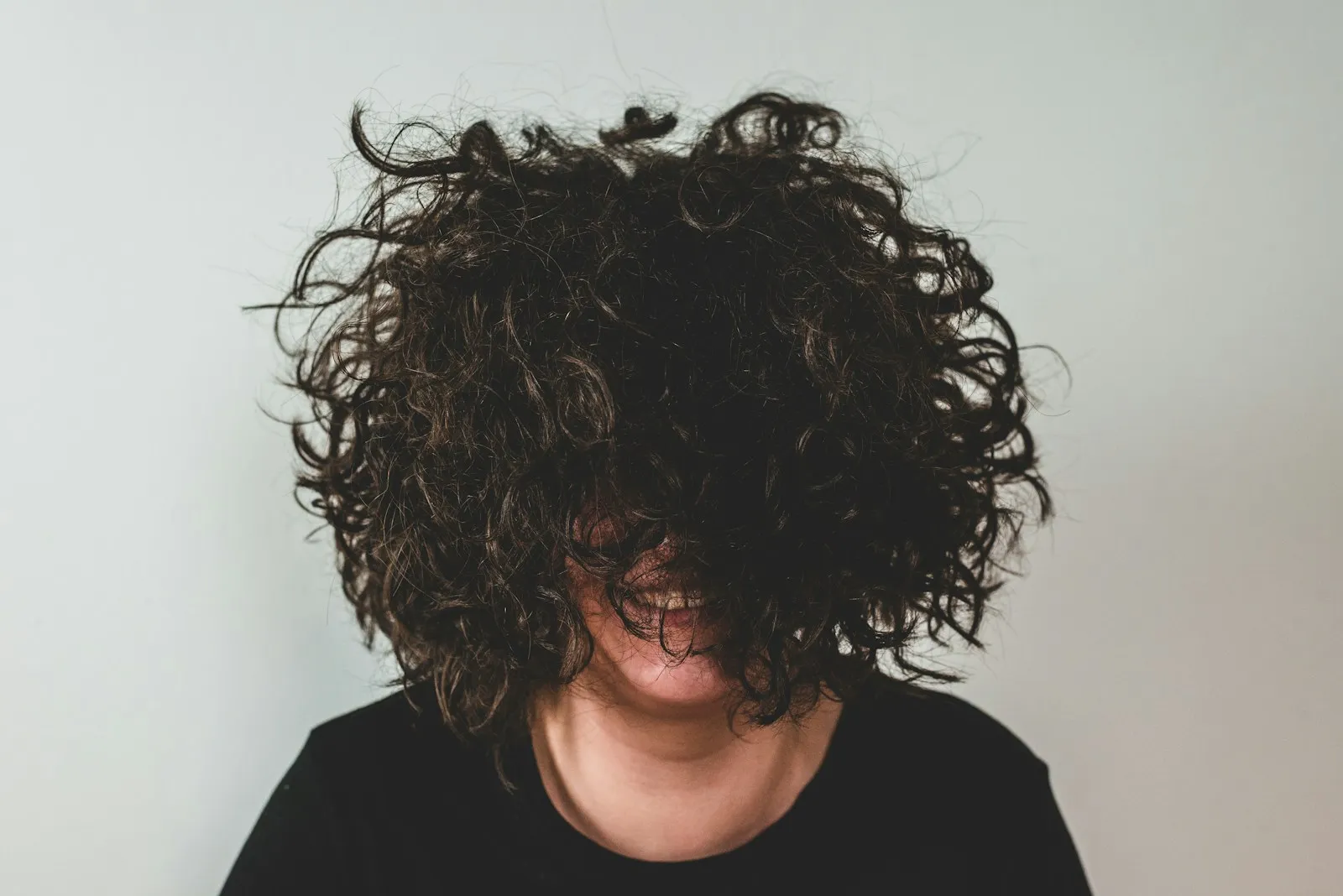 Girl with curly hair in front of her face