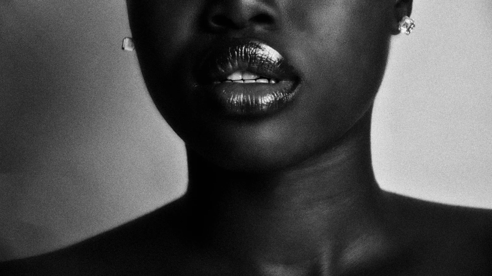 Black-and-white close-up of a woman's lips, chin and neck.