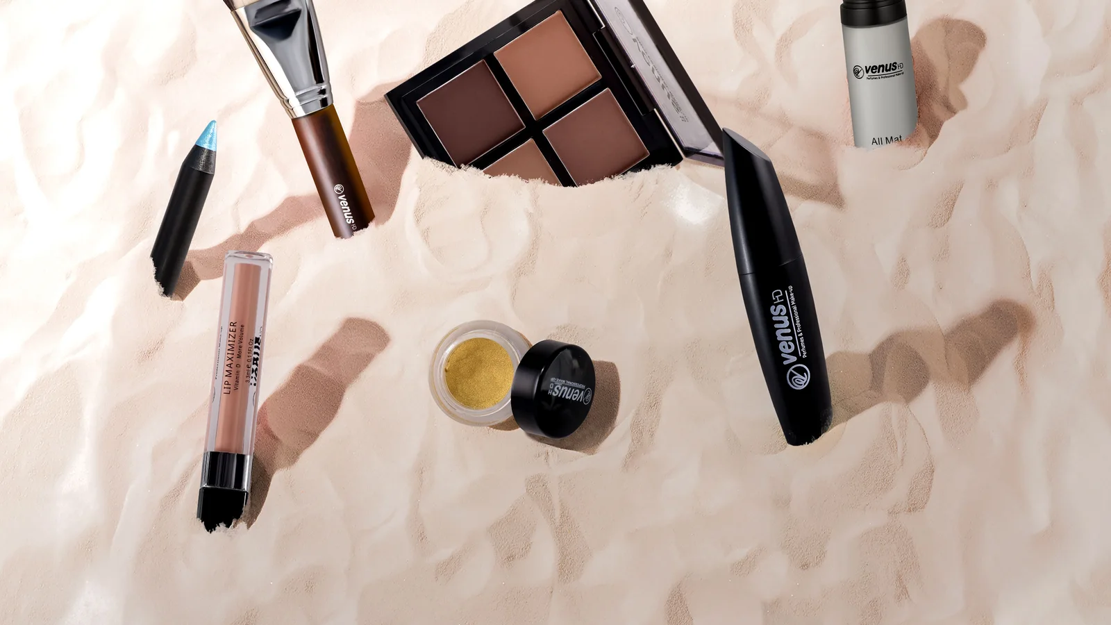 Foundation, eye make-up, brushes and an open lipstick arranged on fabric.