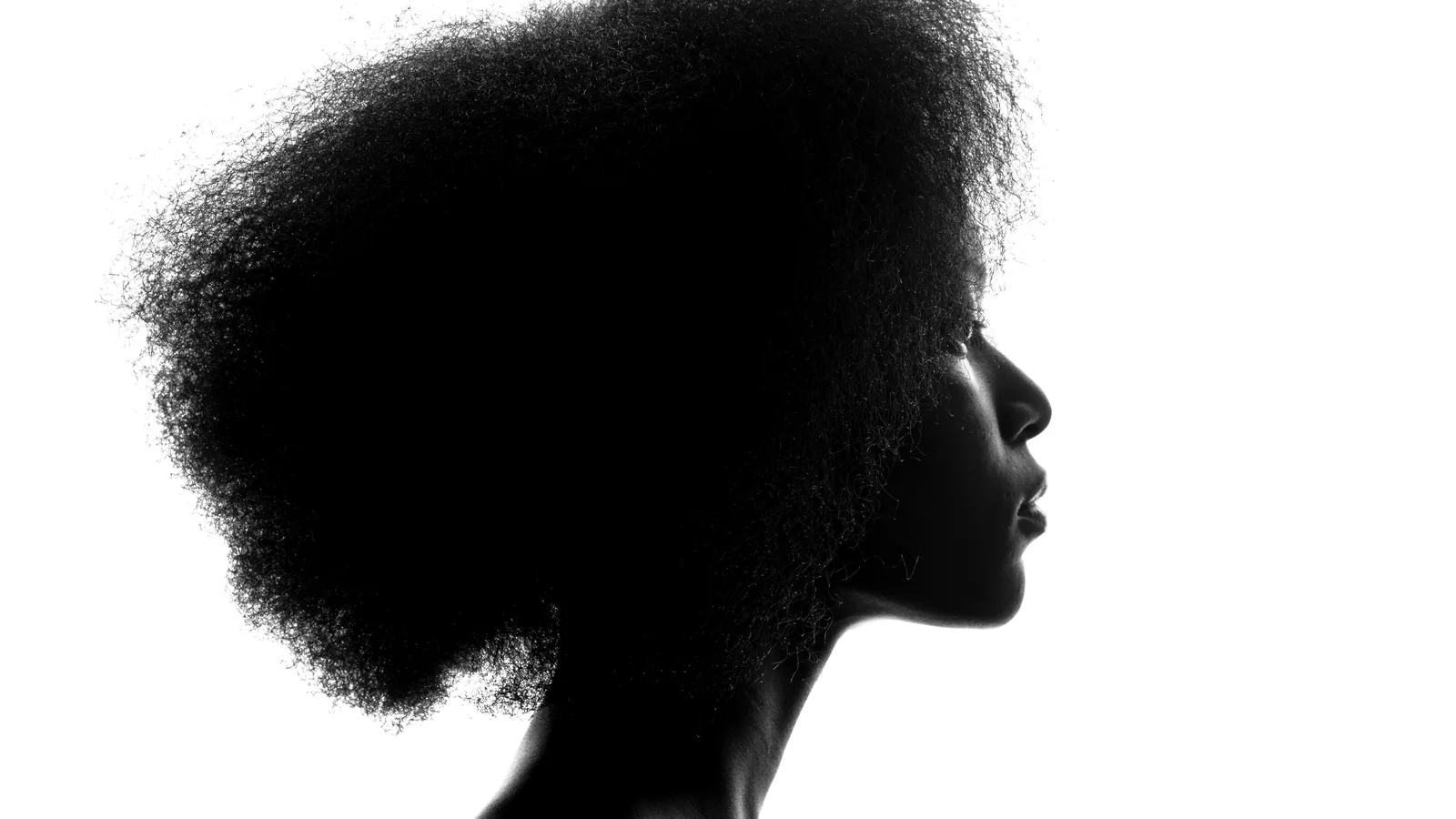 Black-and-white side profile of a woman with natural textured hair.