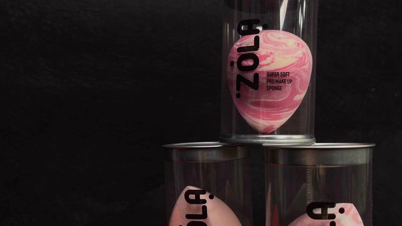Bright make-up sponges beside small transparent cosmetic containers.