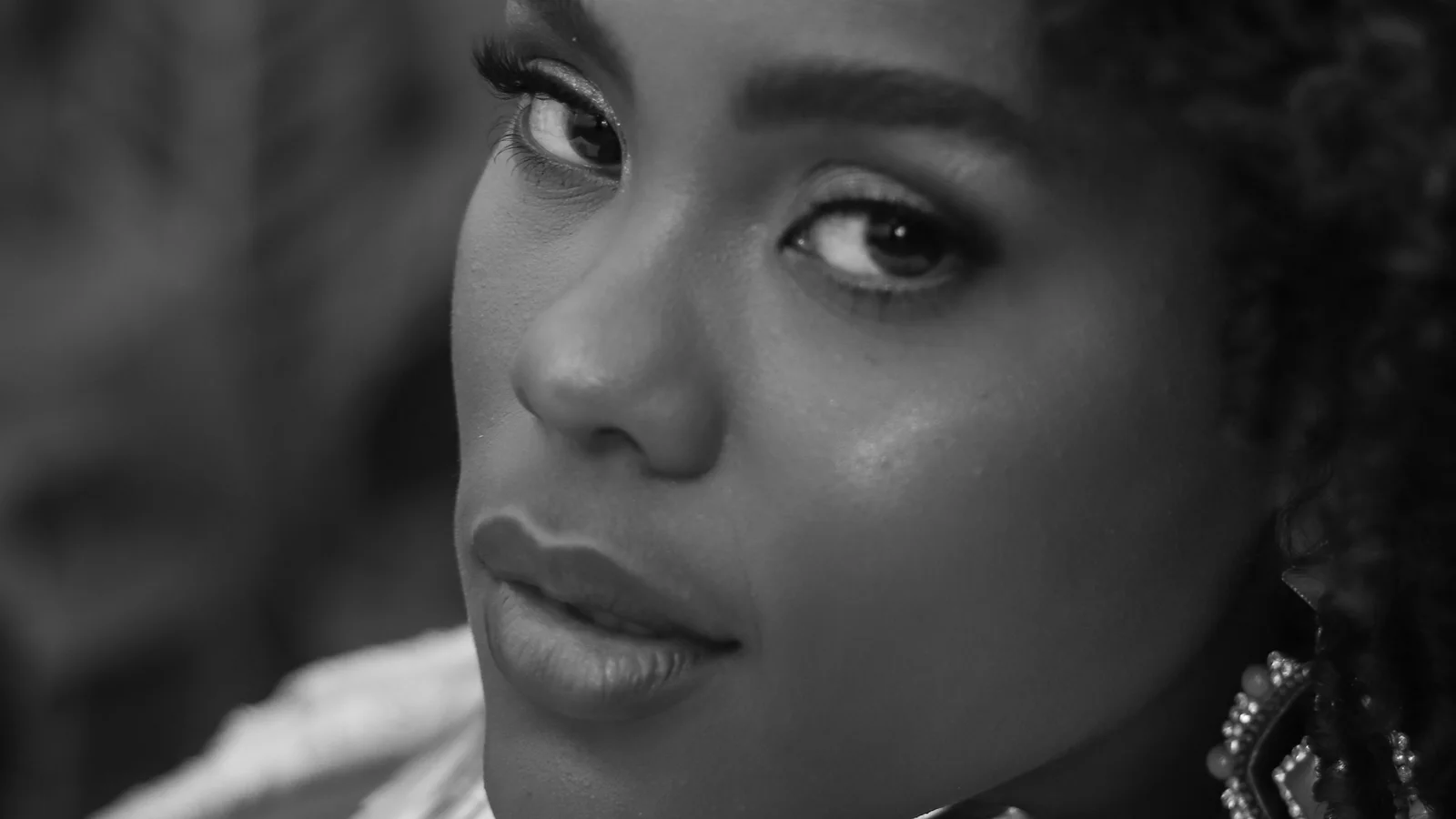 Black-and-white portrait of a woman looking back over one shoulder.