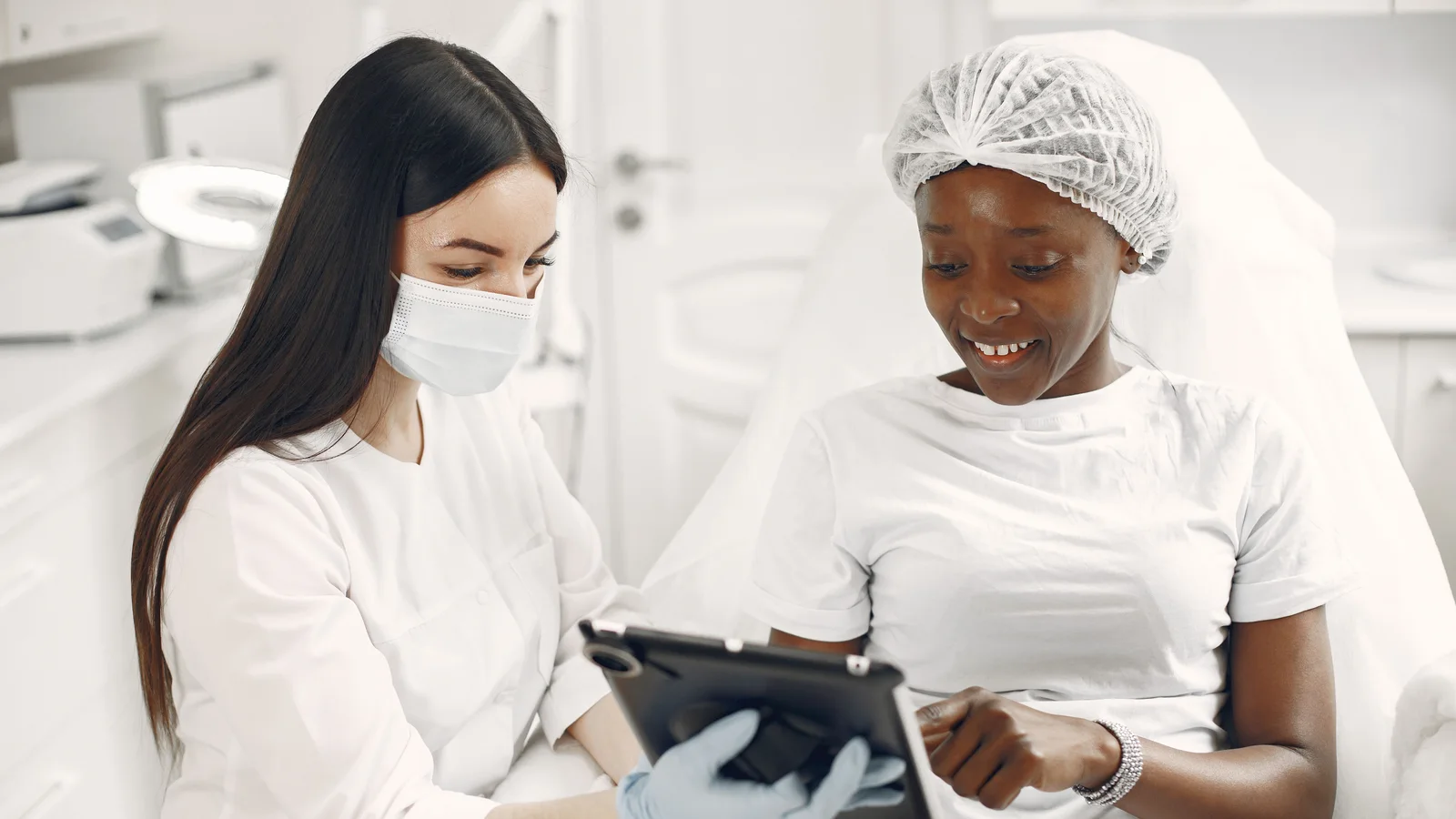 Two women looking at a tablet during a skincare consultation.