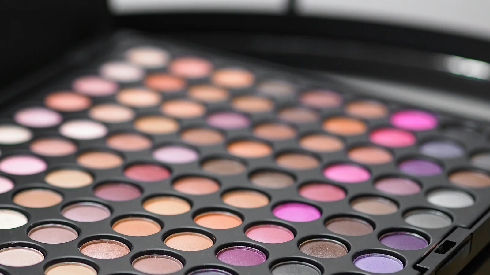 An open palette with many circular colour pans on a dark surface.