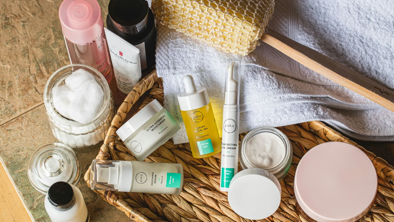 Small bottles and jars with a toiletry basket, towels and a brush.